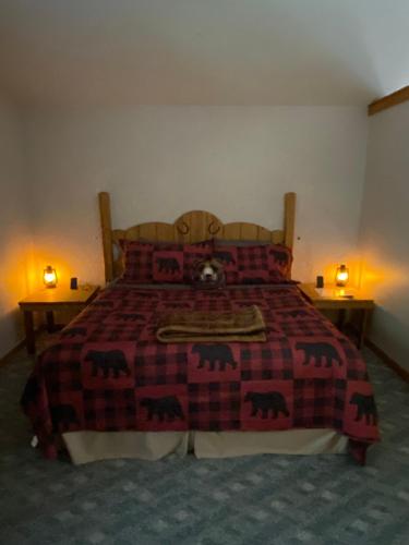 a bedroom with a bed with a red blanket and two lamps at Cedar Creek Cabins #1 - Giant Spa Tub, Large Wooded Porch, Full Kitchen, 1 Bedroom in Eureka Springs