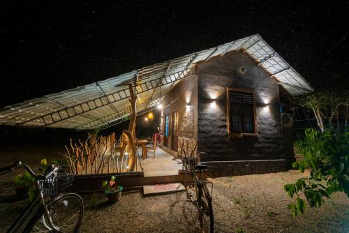 a small house at night with bikes parked in front at Ceylon Resort in Wilpattu