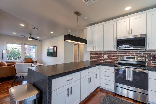 a kitchen with white cabinets and a black counter top at PHX Retreat Fully Remodeled Historic Home in Phoenix