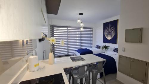 a room with two beds and a desk with a laptop at Curitiba VIP Studio 21 in Temuco