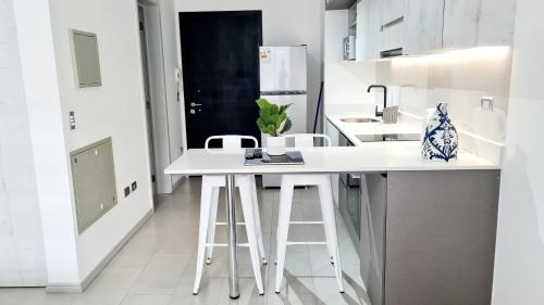 a kitchen with a white counter and stools at Curitiba VIP Studio 21 in Temuco