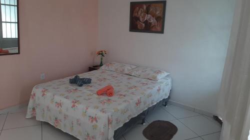 um pequeno quarto com uma cama com uma bolsa vermelha em Apartamento aconchegante 12 min da praia em Cabo Frio