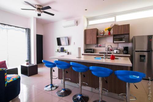 una cocina con taburetes de barra azul en un mostrador en Jaco Modern & Beach Apartment - Lapa Living A1, en Jacó