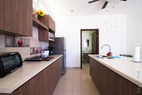 a kitchen with a counter and a refrigerator at Jaco Modern & Beach Apartment - Lapa Living A1 in Jacó