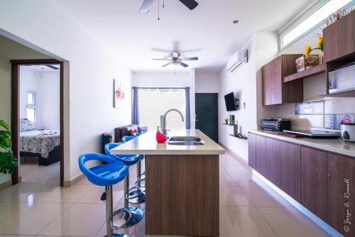 a kitchen with a sink and two blue stools at Jaco Modern & Beach Apartment - Lapa Living A1 in Jacó