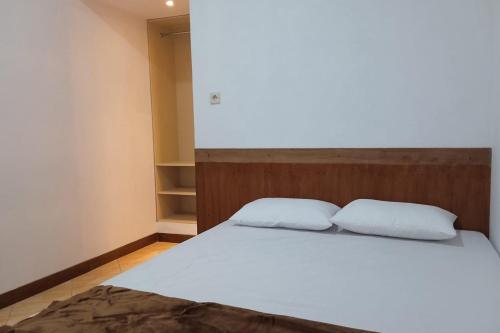 a bedroom with a bed with two white pillows at Gorland Hostel near GOR Satria Purwokerto Mitra RedDoorz in Purwokerto