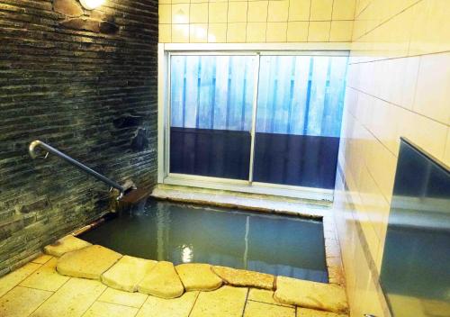 a pool of water in a room with a window at ATAMI SPRING TERRACE HOTEL in Atami