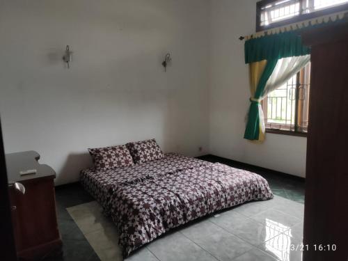 a bedroom with a bed and a window at Kelana 1 Luxury Homestay Semarang, 3 bedrooms in Semarang