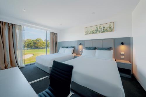 a hotel room with two beds and a window at The Select Inn Ryde in Sydney