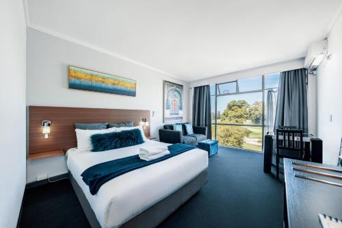 a hotel room with a large bed and a large window at The Select Inn Ryde in Sydney