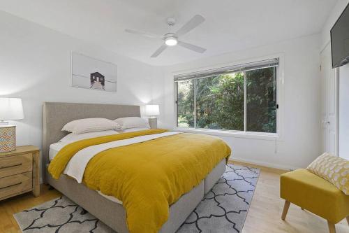 a bedroom with a large bed and a window at Watonga Waves in Port Macquarie