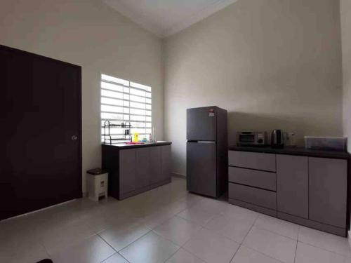a large kitchen with a refrigerator and a window at M Guest House in Muar