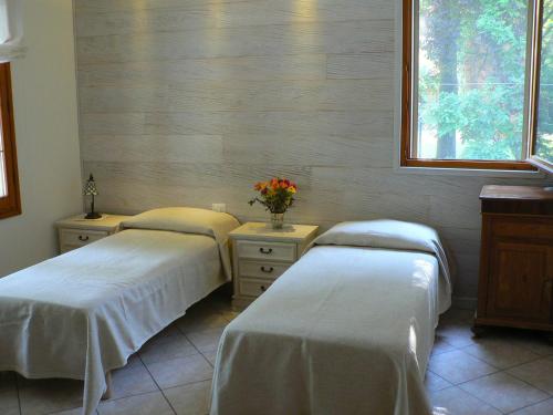 a room with two beds and a window at La Quercia e il Gelso in Baricella