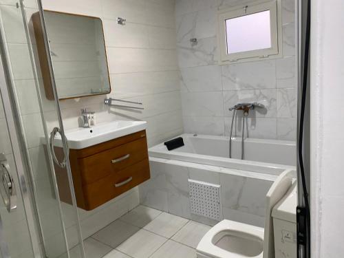 a bathroom with a sink and a tub and a toilet at Residence Studio grâce in Abidjan