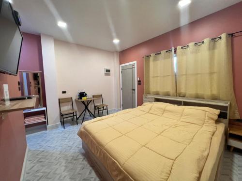 a bedroom with a bed and a table and chairs at 243Hotel in Ta Phraya