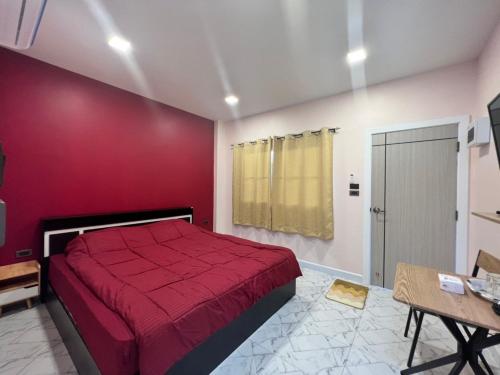 a bedroom with a bed and a red wall at 243Hotel in Ta Phraya