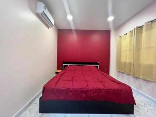 a red bed in a room with a red wall at 243Hotel in Ta Phraya