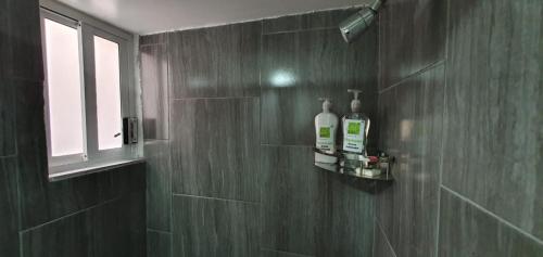 uma casa de banho com duas garrafas de sabão na parede em Bogotá hermoso departamento en CDMX em Cidade do México