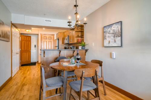a kitchen and dining room with a wooden table and chairs at Incredible Mountain View Townhouse in DT Canmore w/ A/C & U/A Parking in Canmore