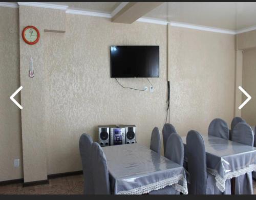 einen Konferenzraum mit einem Tisch und Stühlen sowie einem TV in der Unterkunft Adilet Fatima in Bischkek