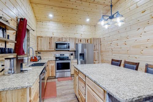 a kitchen with wooden cabinets and a large counter top at Cozy Bear Cabin #1 in Sautee Nacoochee