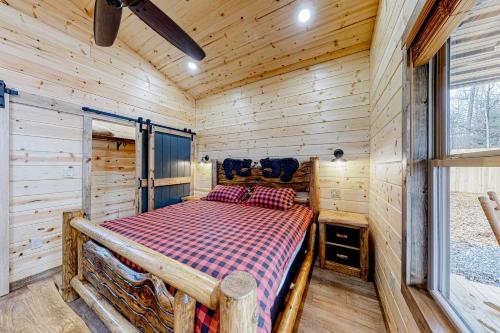 a bedroom with a bed in a wooden cabin at Cozy Bear Cabin #1 in Sautee Nacoochee