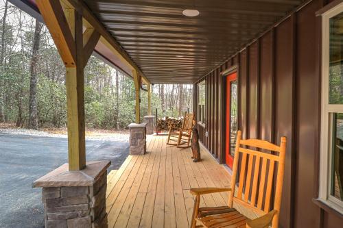 a covered porch of a house with chairs on it at Cozy Bear Cabin #1 in Sautee Nacoochee