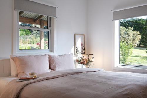 1 Schlafzimmer mit einem großen Bett und 2 Fenstern in der Unterkunft Acacia House in Eganstown