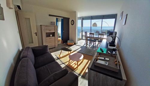 - un salon avec un canapé et une vue sur l'océan dans l'établissement Trois appartements secteur FONCILLON PLAGE, à Royan