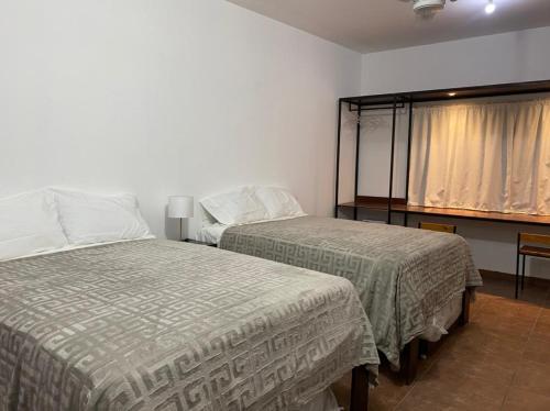 1 dormitorio con 2 camas y ventana. en CASA ROMEL, en Ciudad Valles