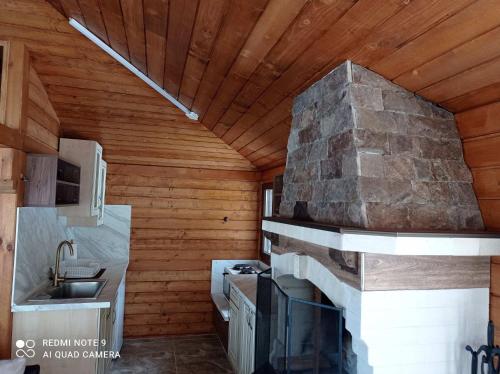 une cuisine avec une cheminée en pierre dans une maison dans l'établissement Вила Хоризонт, à Tsigov Chark