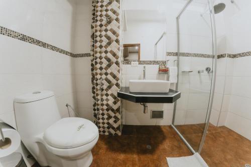a bathroom with a toilet and a sink at Shushupe Hotel in Tingo María