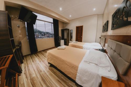 Cette chambre comprend 2 lits et une télévision à écran plat. dans l'établissement Shushupe Hotel, à Tingo María