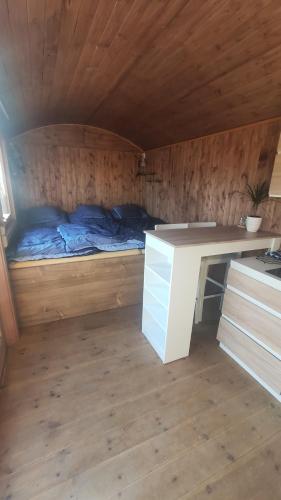 a small room with a bed and a desk in it at Maringotka/tiny house SEN VYSOČINA in Věstoňovice