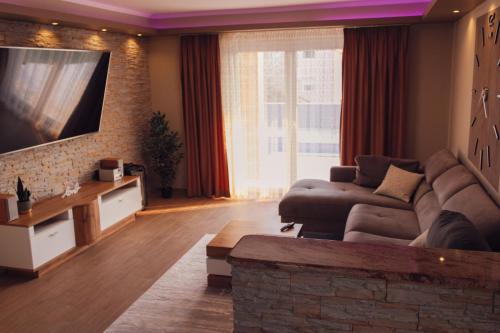 ein Wohnzimmer mit einem Sofa und einem TV in der Unterkunft Villa Valf in Posedarje