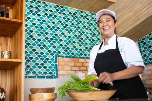 a woman standing in a kitchen preparing food at Cielo Boutique Hotel & Spa Samui in Bophut 
