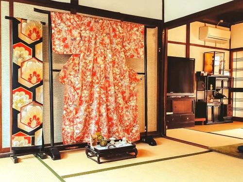 泉佐野市にあるゲストハウス古民家　和のテレビ付きの客室内の大きなカーテン
