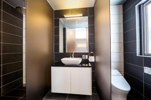 a bathroom with a white sink and a mirror at Phoenix Chalets by HHG in Hakuba