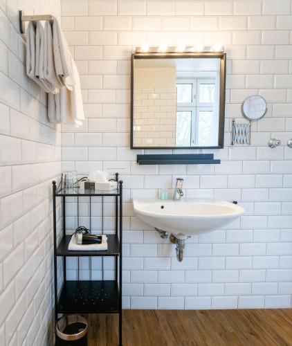 a white bathroom with a sink and a mirror at Hotel Beim Schupi Karlsruhe in Karlsruhe