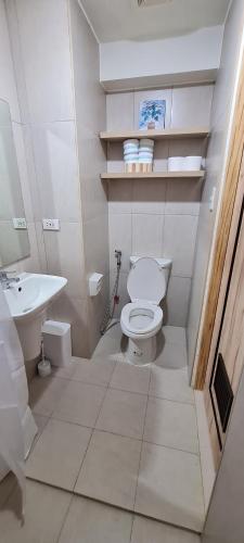 a white bathroom with a toilet and a sink at Inspiria Condo Units beside Abreeza Mall Davao in Davao City