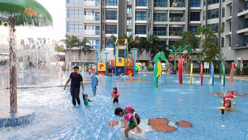 a woman and children playing in a water park at Atlantis Residence Melaka By GGM in Melaka