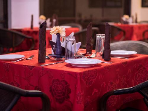a red table with plates and utensils on at HOTEL CENTRAL PARK & CONFERENCE CENTRE in Nairobi