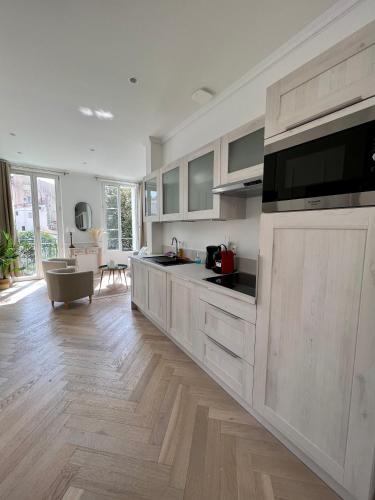 une cuisine avec des armoires blanches et un salon dans l'établissement amazing new property in the heart of the old town of antibes, à Antibes