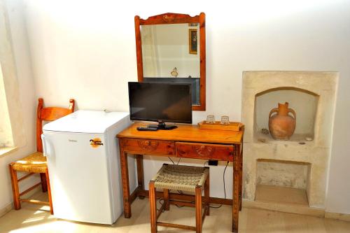 a room with a desk with a refrigerator and a mirror at Hotel Byzantine in Rethymno