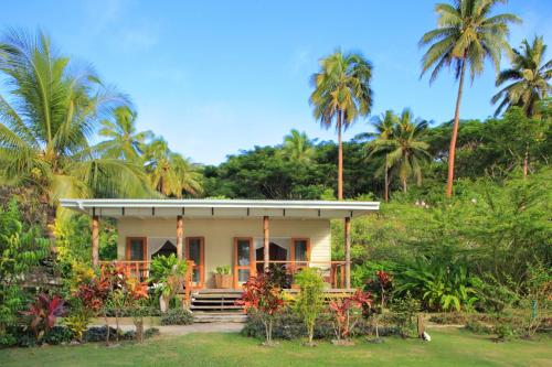 a house with palm trees in front of it at Sau Bay Resort & Spa in Waiyevo