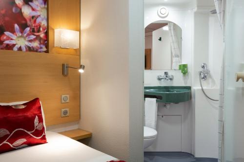 オルレアンにあるFasthotel Orleans Zénithの洗面台とトイレ付きのバスルームの写真2枚