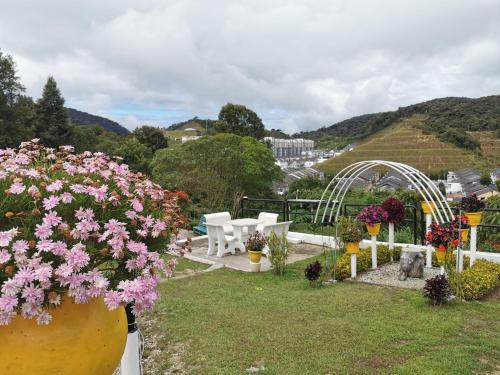 a garden with flowers and a table and chairs at Dear Dino Villa Cameron Highlands in Cameron Highlands