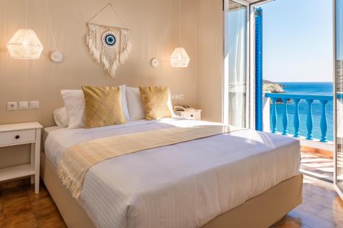 a bedroom with a bed with a view of the ocean at Villa Pitsa in Batsi