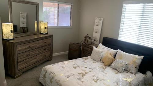a bedroom with a bed with a dresser and a mirror at SU CASA ES MI CASA in Las Vegas