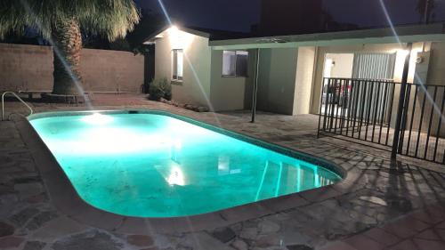 a swimming pool in a yard at night at SU CASA ES MI CASA in Las Vegas